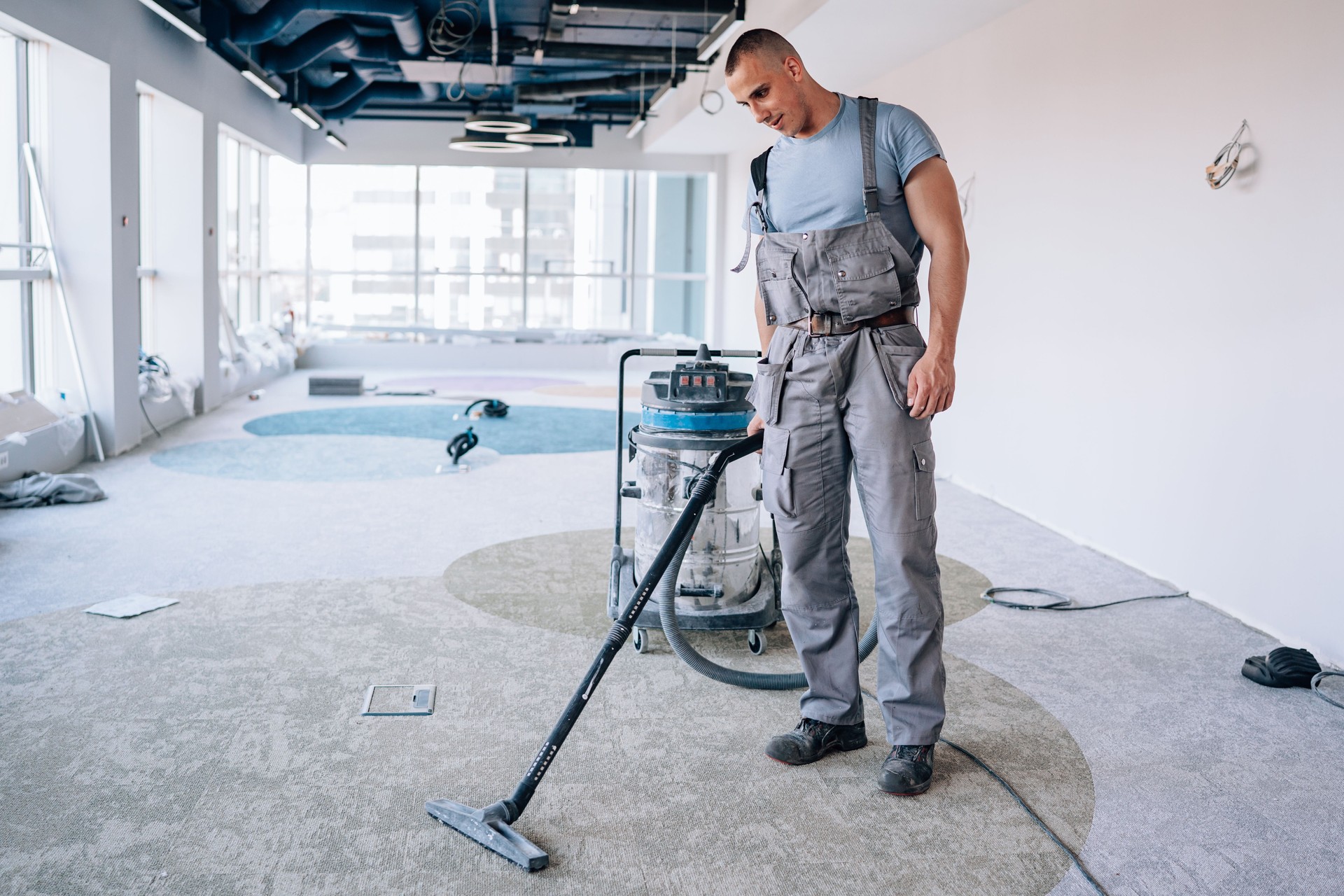 commercial cleaning lancaster county carpet Young man meticulously vacuums the carpet after installation